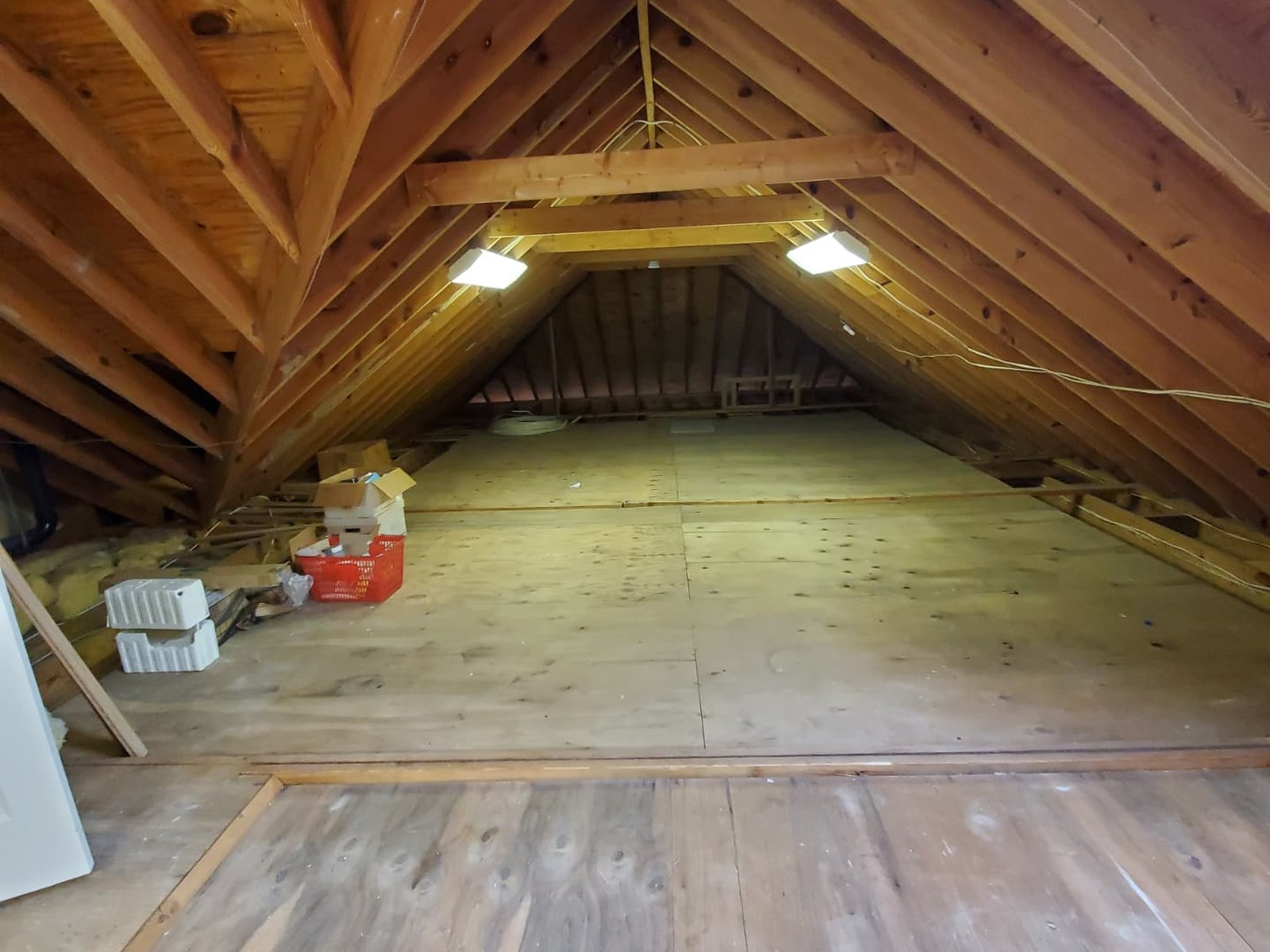 A freshly cleared attic with clean plywood flooring