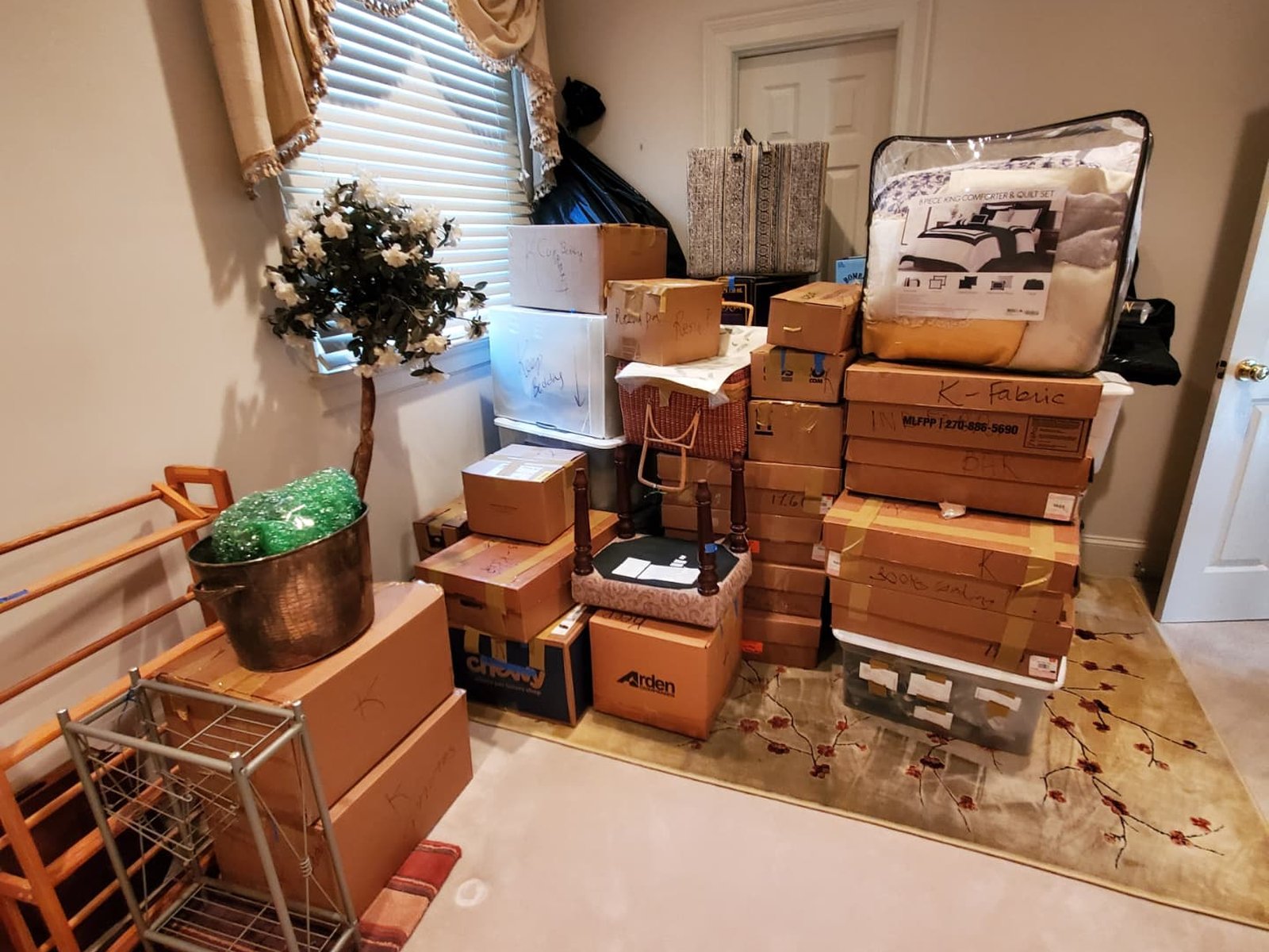 A bedroom with boxes organized by category ahead of a move